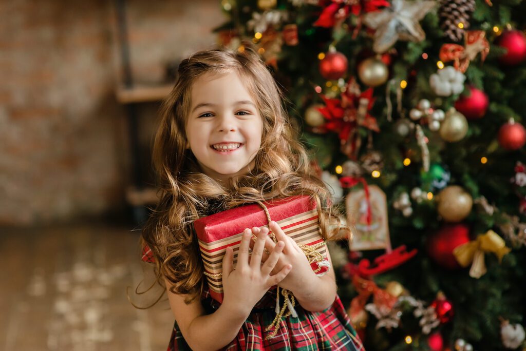 dziewczynka z zapakowanym świątecznym prezentem