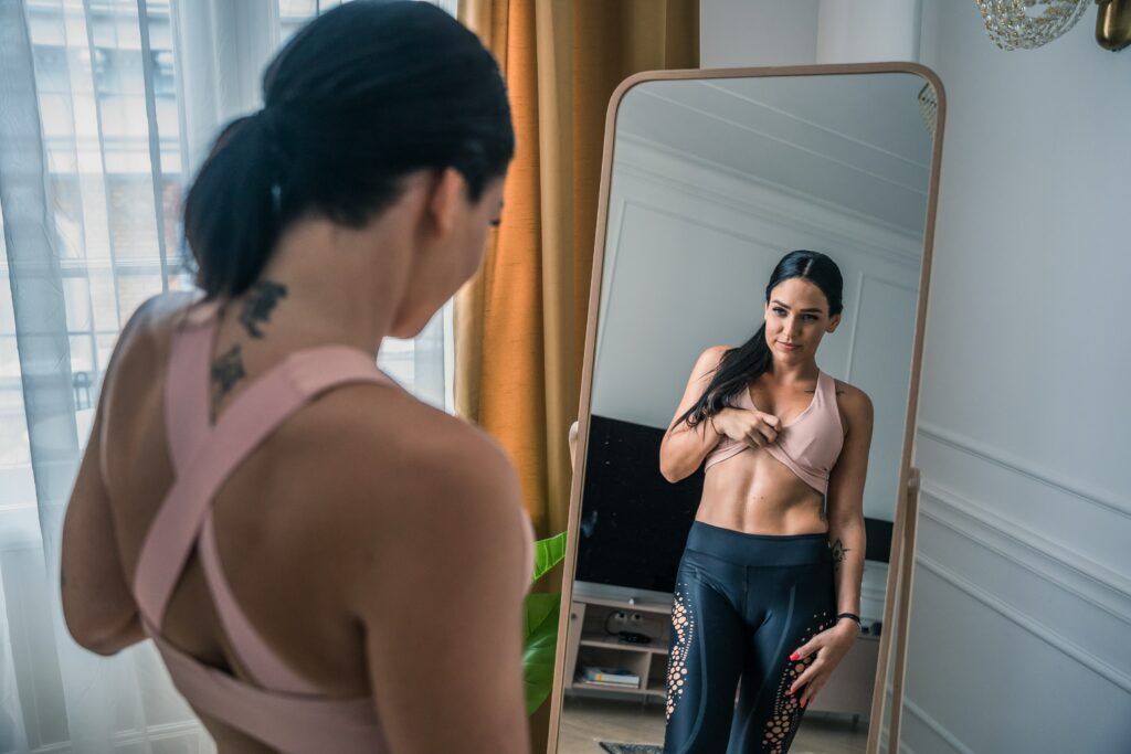 Kobieta przygląda się w lustrze swojej idealnej figurze.