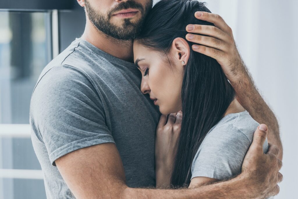 Mężczyzna przytula smutną kobietę