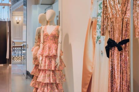 Manekiny w eleganckich sukienkach w butiku, różowa koronkowa sukienka z falbanami, błyszcząca złota suknia wieczorowa, modna odzież damska.