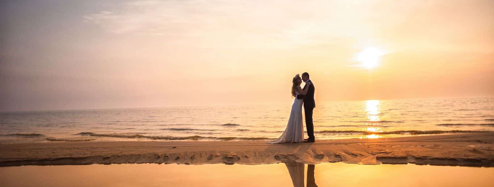 ślub nad morzem: para młoda o zachodzie słońca