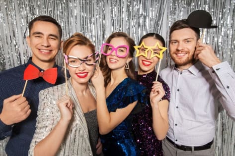 goście bawią się pozując do zdjęć. Fotobudka cena