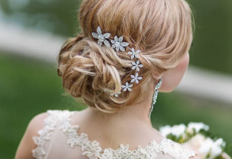 Upięcie ślubne z ozdobnymi spinkami, elegancka fryzura z plecionką dla panny młodej.