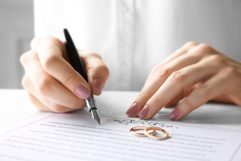 kobieta podpisuje dokumenty, żeby wziąć ślub w plenerze