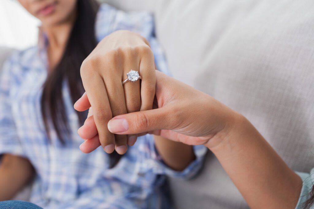 kobieta prezentuje na której ręce nosi się pierścionek zaręczynowy