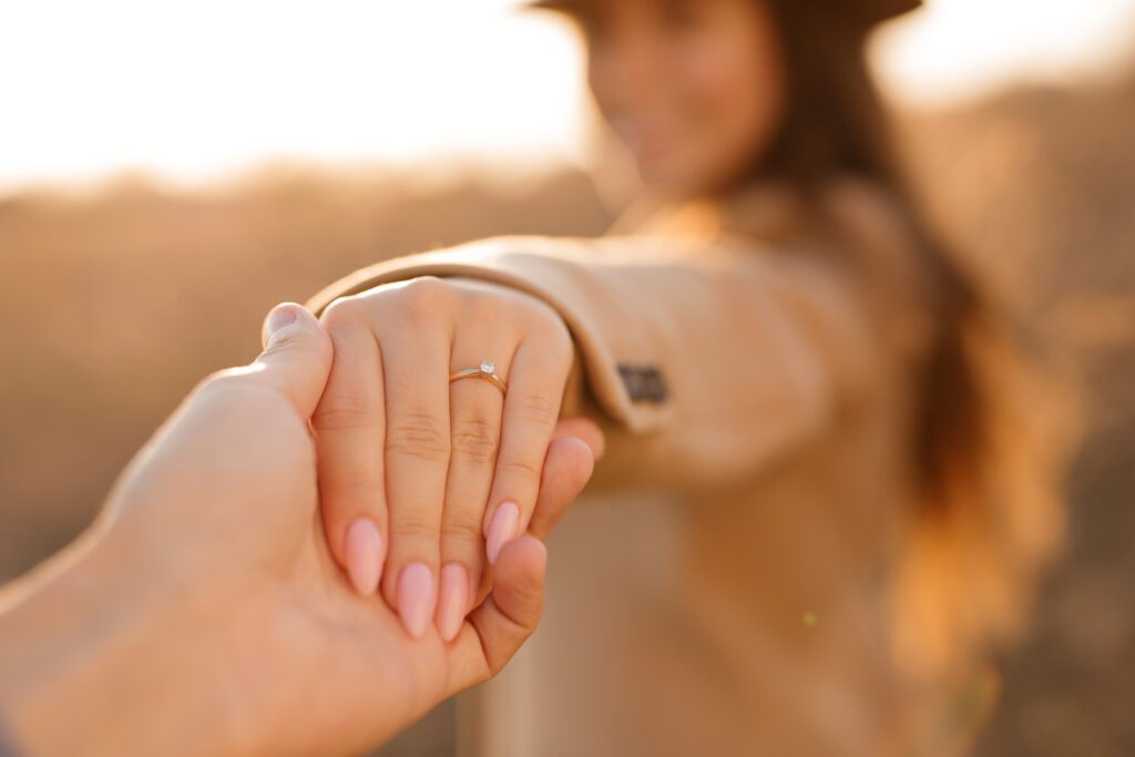 kobieta pokazuje na której ręce nosi się pierścionek zaręczynowy