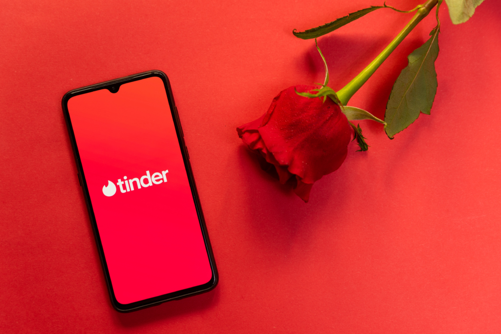 Telefon z aplikacją Tinder i czerwona róża